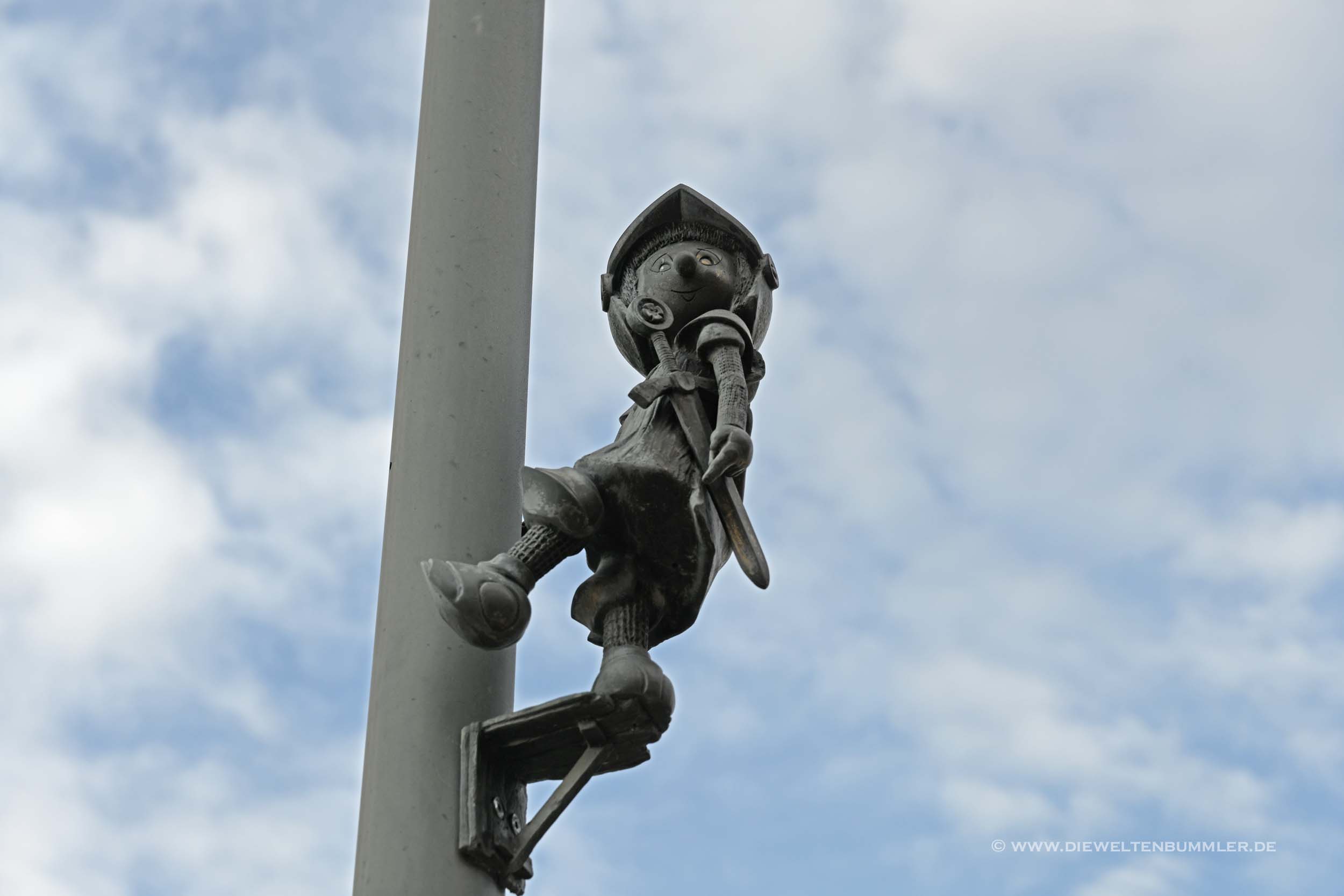 Am Bahnhof klettert Marianek an einer Straßenlaterne