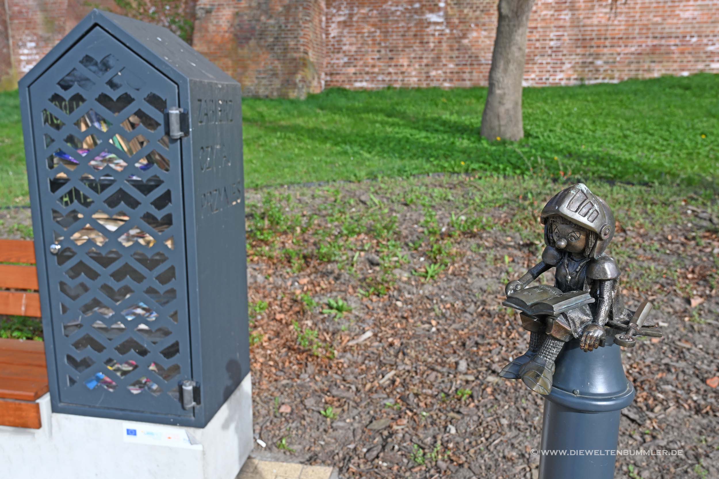 Er sitzt direkt neben einem Bücherschrank